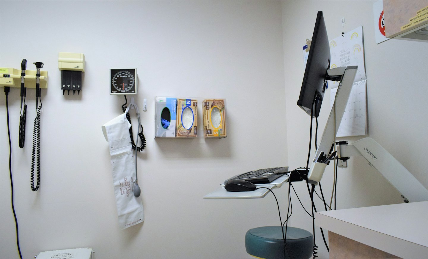 Doctor's examination room with medical equipment and computer.